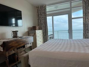 a bedroom with a bed and a large window at 2501 S Ocean Blvd, 0811 - Ocean Front Sleeps 8 in Myrtle Beach