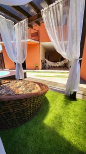a patio with white curtains and green grass at Partiu Praia SC in Guarda do Embaú