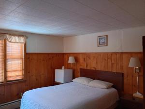 a bedroom with a white bed and a window at The Ashley in Saranac Lake