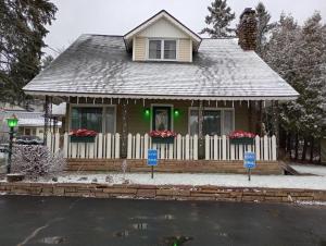 uma pequena casa com uma cerca branca em The Ashley em Saranac Lake