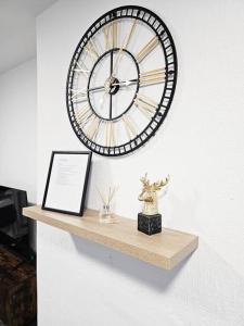 a large clock hanging on a wall above a shelf at Swinton, Manchester (2) in Manchester