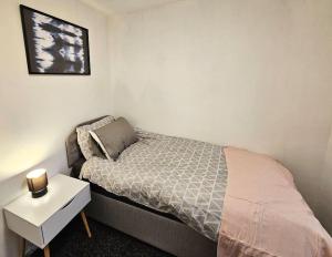 um pequeno quarto com uma cama e uma mesa de cabeceira em Swinton, Manchester (2) em Manchester