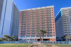 ein großes Apartmenthaus mit einem Baum davor in der Unterkunft 1604 N Ocean Blvd, 0703 - Ocean Front Sleeps 6 in Myrtle Beach