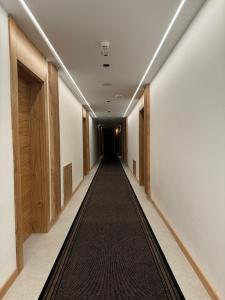 um longo corredor com um longo corredor alcatifado em Apart Hotel Zlatni Javor, Apartment 410 em Jahorina