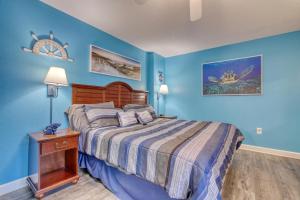 a bedroom with blue walls and a bed with a wooden headboard at 2501 S Ocean Blvd, 0929 - Ocean View Sleeps 8 in Myrtle Beach