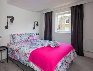 una camera con letto rosa e finestra di Shirlock Home - Italianflat a Londra