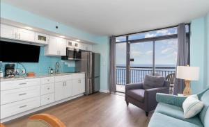 a kitchen with a living room with a view of the ocean at 4800 S Ocean Blvd, 0915 - Ocean Front Sleeps 6 in Myrtle Beach