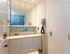 bagno con lavandino e specchio di Shirlock Home - Italianflat a Londra