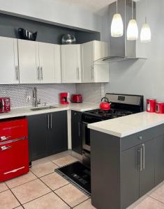 a kitchen with black and white cabinets and red appliances at Ocean Dream in Miami Beach