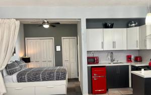 a bedroom with a bed and a kitchen with white cabinets at Ocean Dream in Miami Beach