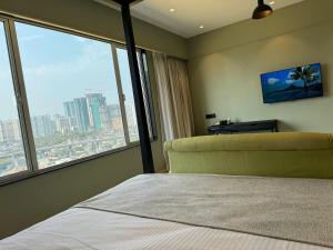 a bedroom with a bed and a large window at Hotel Mumbai House, Malad in Mumbai