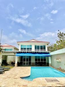 una casa con piscina frente a ella en Villa En La Playa Cartagena #1, en Cartagena de Indias