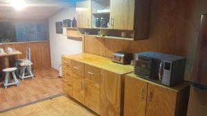 a kitchen with wooden cabinets and a microwave on a counter at Hermosa casa en el centro de Coyhaique in Coihaique