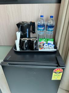 a tray on top of a refrigerator with water bottles at Hotel Mumbai House, Malad in Mumbai