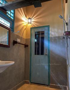 een badkamer met een groene deur en een wastafel bij Liyara Nature Farm Resort in Gampaha