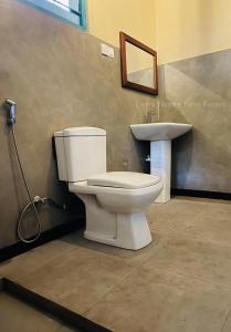a bathroom with a toilet and a sink at Liyara Nature Farm Resort in Gampaha