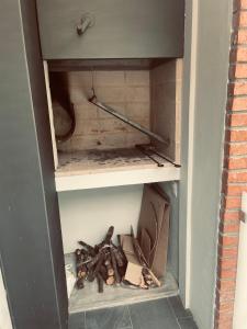 an open cabinet with a box and some wood at Nuevo y confortable apto con parrilla in Montevideo