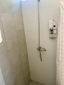 La salle de bains est pourvue d'une douche et d'une porte en verre. dans l'établissement Nuevo y confortable apto con parrilla, à Montevideo