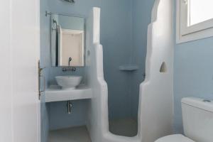W białej łazience znajduje się umywalka i lustro. w obiekcie NINEMIA CALM AND SPA w mieście Kionia