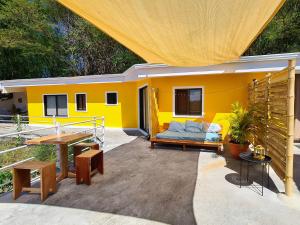 ein gelbes Haus mit einer Couch auf einer Terrasse in der Unterkunft La Casa del Conde in Naranjo