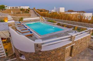 a swimming pool with chairs around it on a resort at Villa Mando in Super Paradise Beach