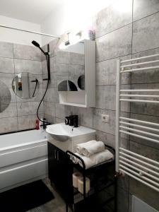 La salle de bains est pourvue d'un lavabo, d'un miroir et d'une douche. dans l'établissement Dream Arena Apartment, à Bacău