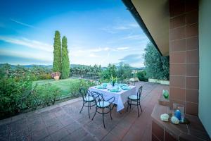 einen Tisch und Stühle auf einer Terrasse mit Aussicht in der Unterkunft Borgo Spedaletto 5 - Dolcevita Holiday in Grassina