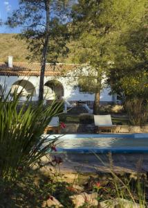 una piscina con un banco junto a una casa en Casa al pie de la Montaña en La Cumbre