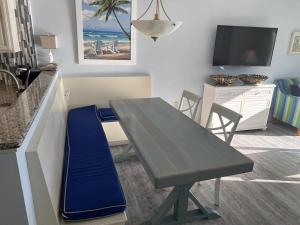 cocina con mesa y banco azul en una habitación en 74th Ave N, 1443-44 - Ocean View Sleeps 8 en Myrtle Beach