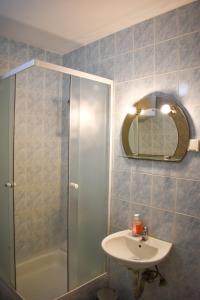 a bathroom with a shower and a sink and a mirror at White Hills Apartments in Budva