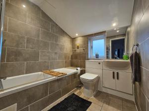 y baño con aseo, bañera y lavamanos. en MAGICAL HARRY POTTER HOME IN WATFORD with FREE off-street PARKING en Watford