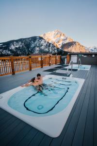 Ein Mann in einem Whirlpool auf einem Deck in der Unterkunft Basecamp Suites Banff in Banff