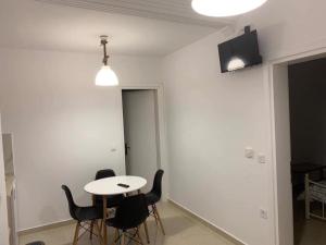 a room with a table and chairs and a television at Petrino Apartments in Kavala