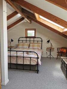 ein Schlafzimmer mit einem schwarzen Bett im Dachgeschoss in der Unterkunft The Old Chapel in Riwaka