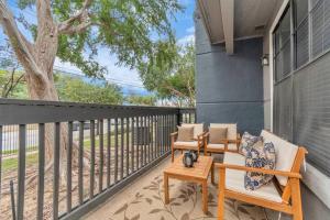 a patio with two chairs and a table on a balcony at The Natural Mirage near Rice Village! in Houston