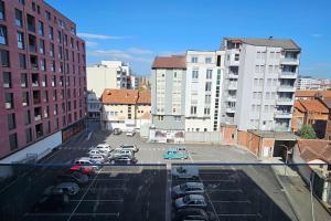 a parking lot with parked cars in a city at The Cozy Flat in Gjakove