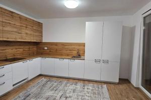 a kitchen with white cabinets and a sink at The Cozy Flat in Gjakove