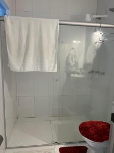 a bathroom with a shower with a toilet and a towel at AP 2 Quartos 6 Pessoas Luxo 200mt Axé Moi in Porto Seguro