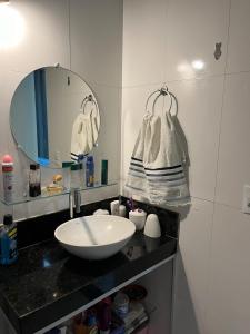 uma casa de banho com um lavatório e um espelho em AP 2 Quartos 6 Pessoas Luxo 200mt Axé Moi em Porto Seguro