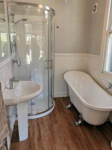 a bathroom with a shower and a tub and a sink at The Old Chapel in Riwaka