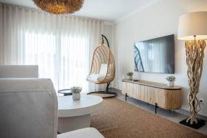 a living room with a couch and a tv at Magnolia Luxury Villa in Vieira de Leiria
