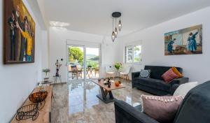 a living room with a couch and a table at Sweet Home Luxury Apartments in Ialyssos