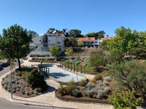 uma vista para um jardim com uma piscina em Discovery Apartment Carnaxide em Carnaxide