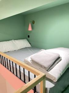 um quarto com 2 camas e um candeeiro rosa em Cozy En-suite Loft in Trendy Local em Londres