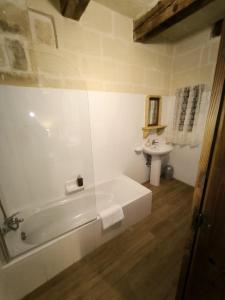 a white bathroom with a tub and a sink at Il figolla b&b in Xagħra