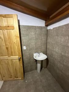 baño con lavabo y puerta de madera en Aldo’s place #2, en Playa Negra