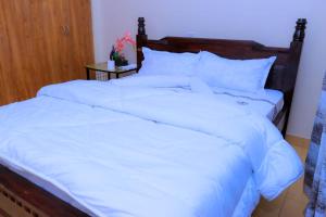 ein großes weißes Bett mit weißer Bettwäsche und Kissen in der Unterkunft CALMCORNER HAVEN HOMES, PATRIDE ENTERPRISES in Kisii