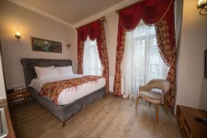 1 dormitorio con 1 cama, 1 silla y ventanas en BeyPort Hotel Taksim, en Estambul