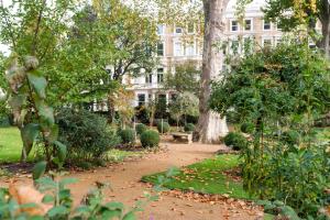ロンドンにあるPleasant Earl's Court Apartment near Hyde Park by UndertheDoormatの背景の像のある庭園
