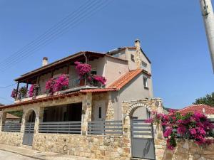 a stone house with flowers on the balcony at Petrino Apartments in Kavala